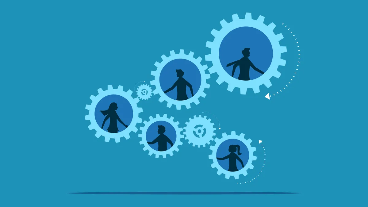 Business people work together to turn the gear wheels.