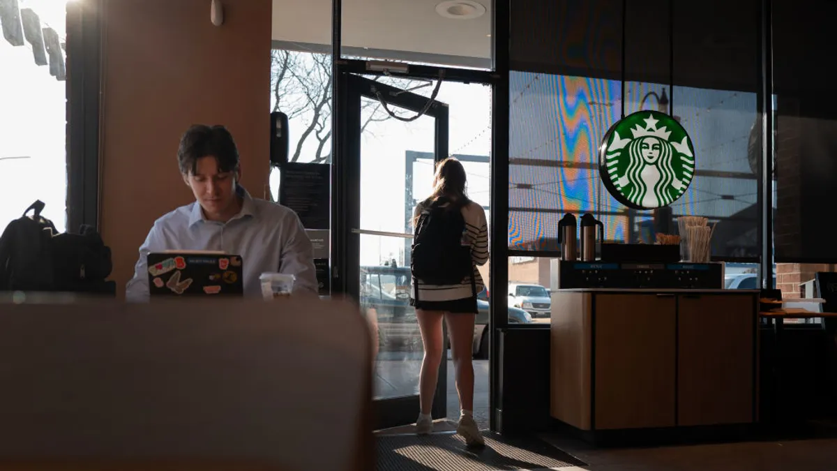 A customer works on a computer inside a Starbucks location.