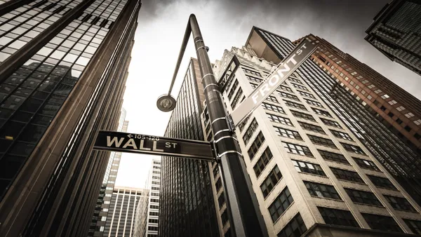 View from the the ground looking up at high rises and Wall St. and Front St. signs.