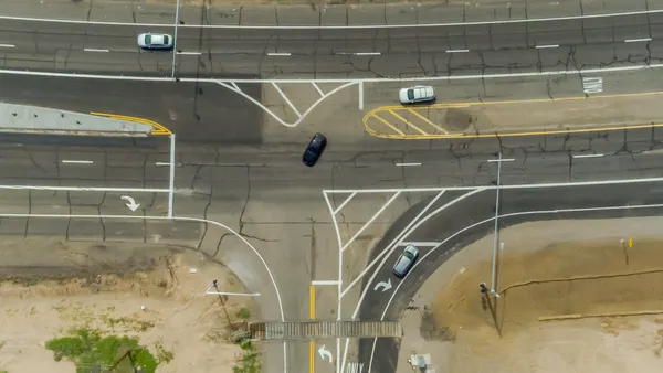 An overhead shot from high in the air of a set of roads that weave into each other on a sunny day.