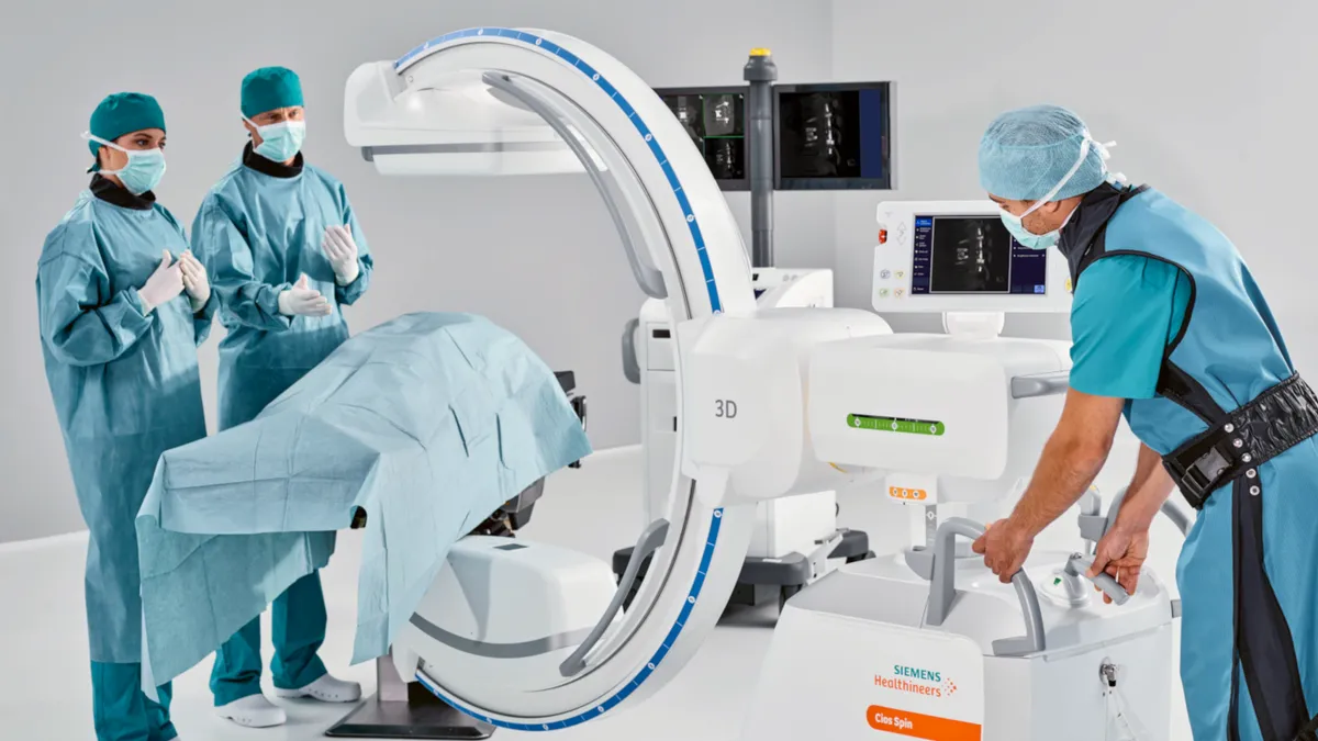 Persons in physician garb standing around Siemens Cios Spin Endobronchial imaging machine