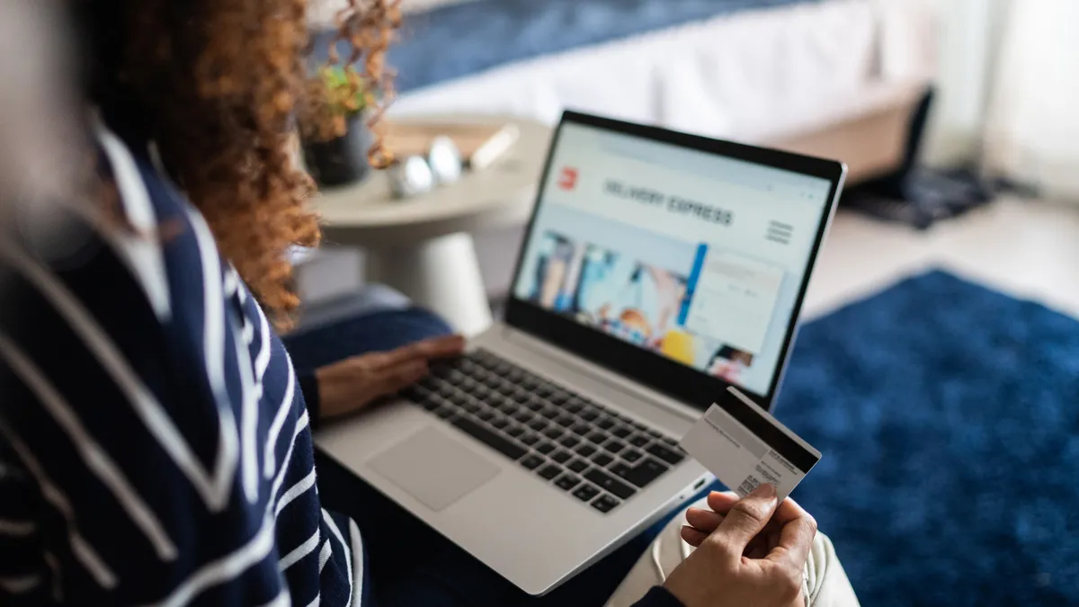 Young woman online shopping using the laptop at home