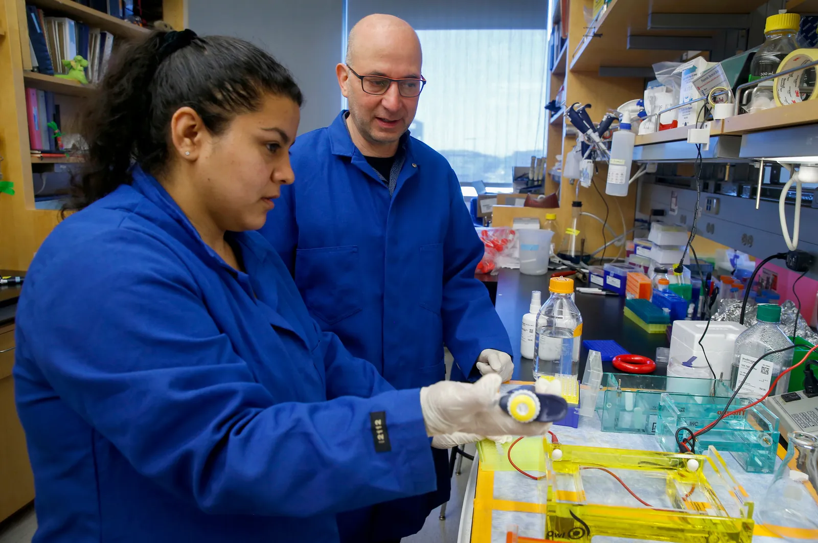 Two people in coats work in lab.