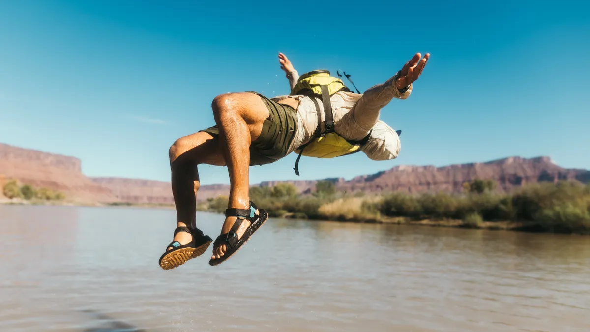 A person doing a backflip wearing Teva sandals