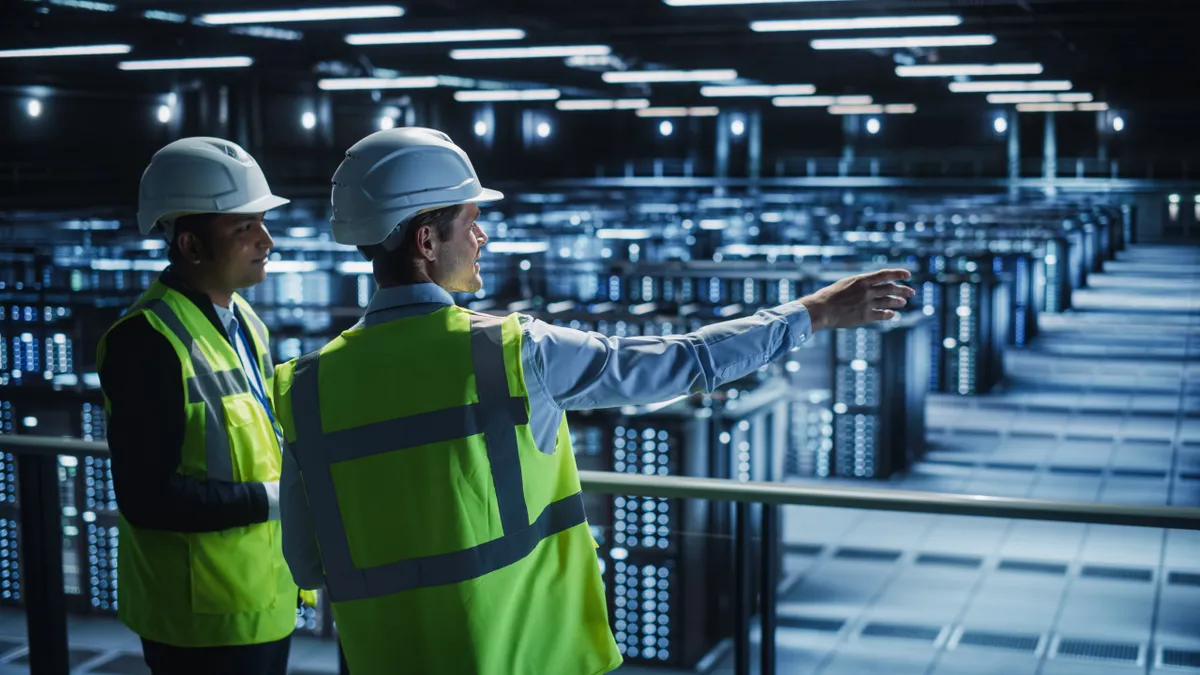 Two engineers overlook a data center and discuss its design and operations.