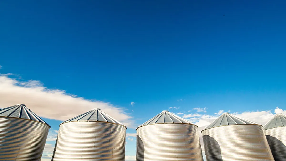 Grain elevators are seen contrasted against a bright blue sky