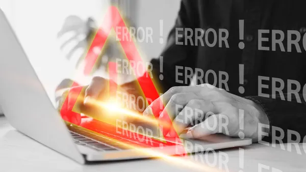 Person at a laptop with an exclamation point and error messaging