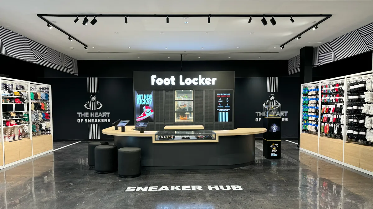 A wall that reads "Foot Locker" with a wood bar-like setup in front of it.