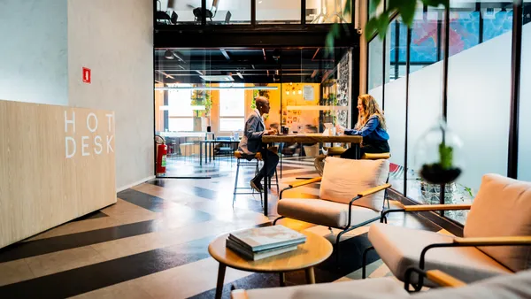 Coworkers meet at a table in a modern coworking space.