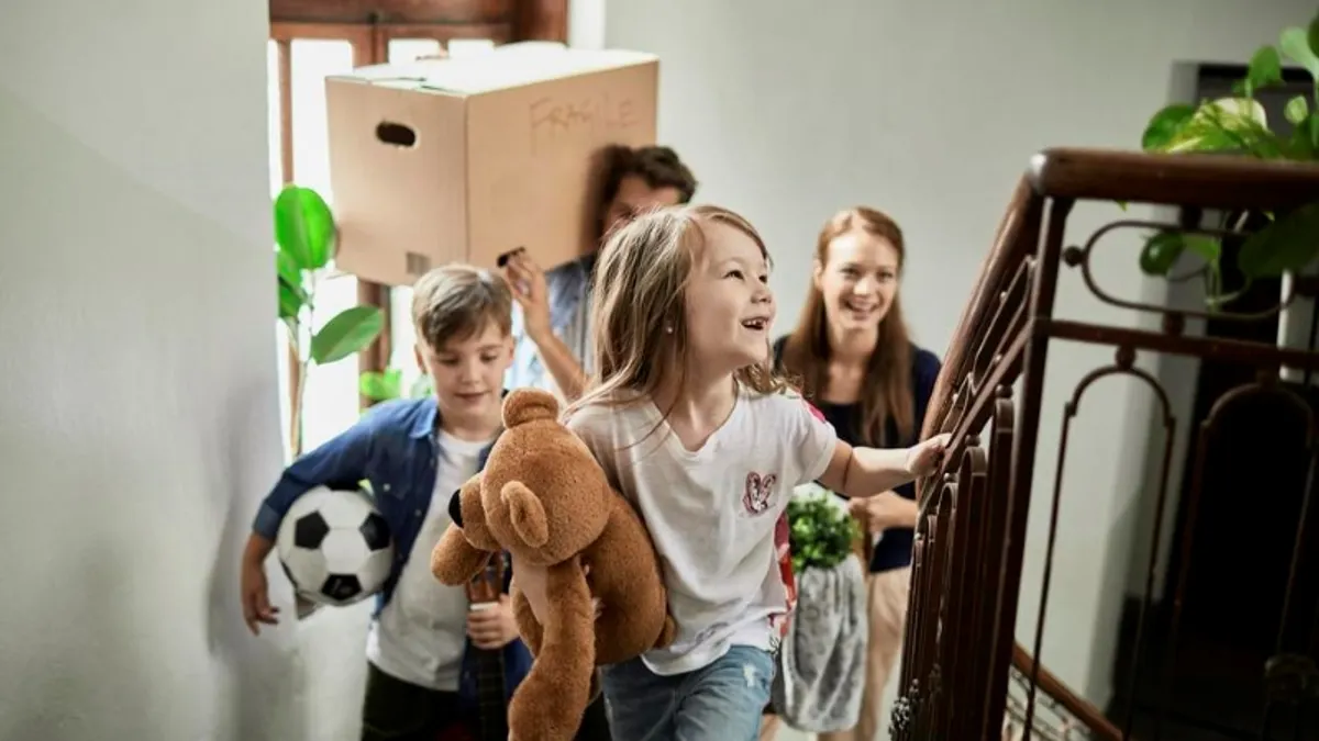 Family walking up stairs carrying their items