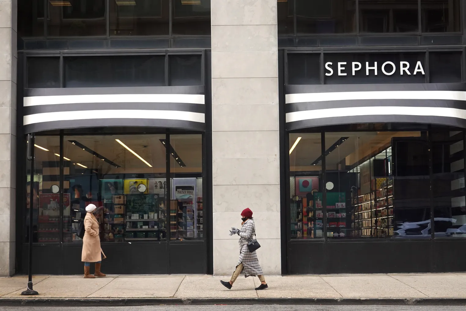 People walk by a Sephora storefront.