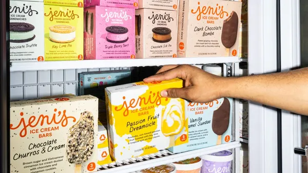 A person reaches into a freezer containing Jeni's frozen treats.