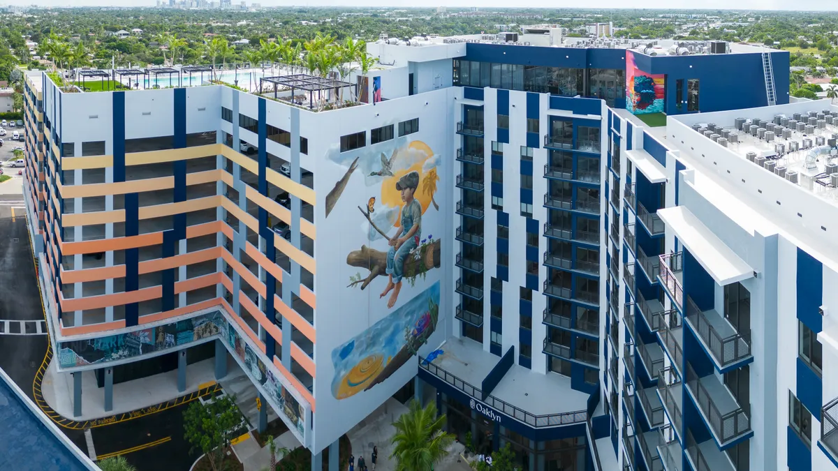 A long, jagged building with a colorful mural on one side.