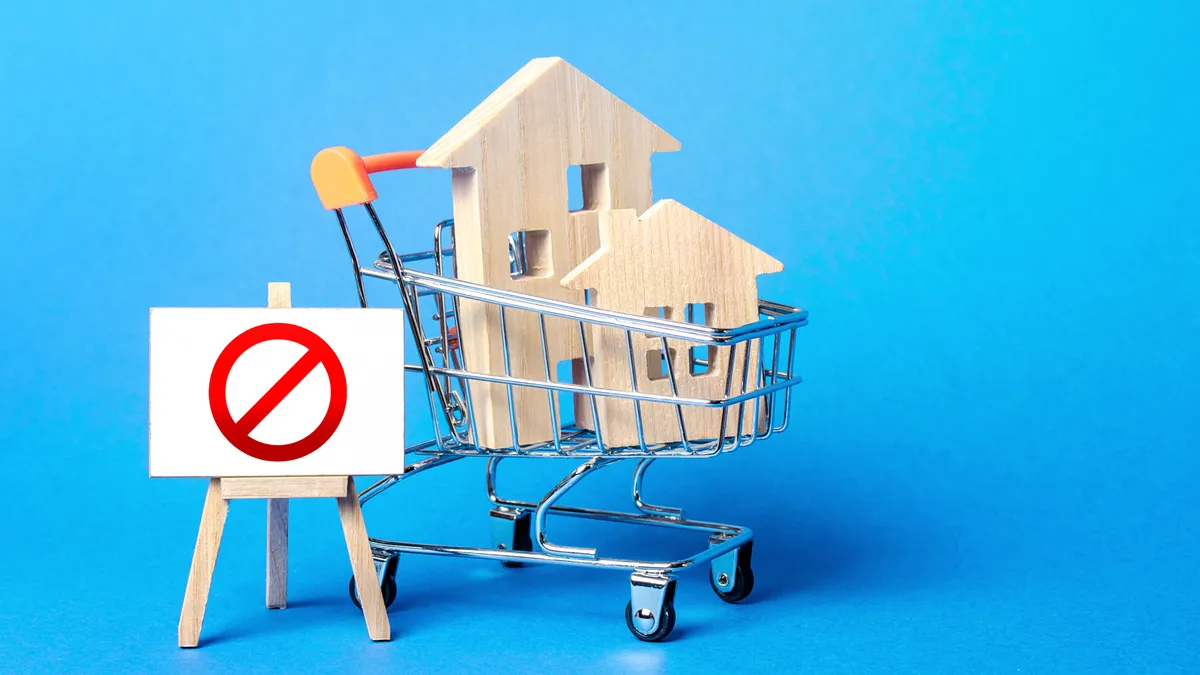 Houses in a shopping cart and easel red prohibition sign NO.