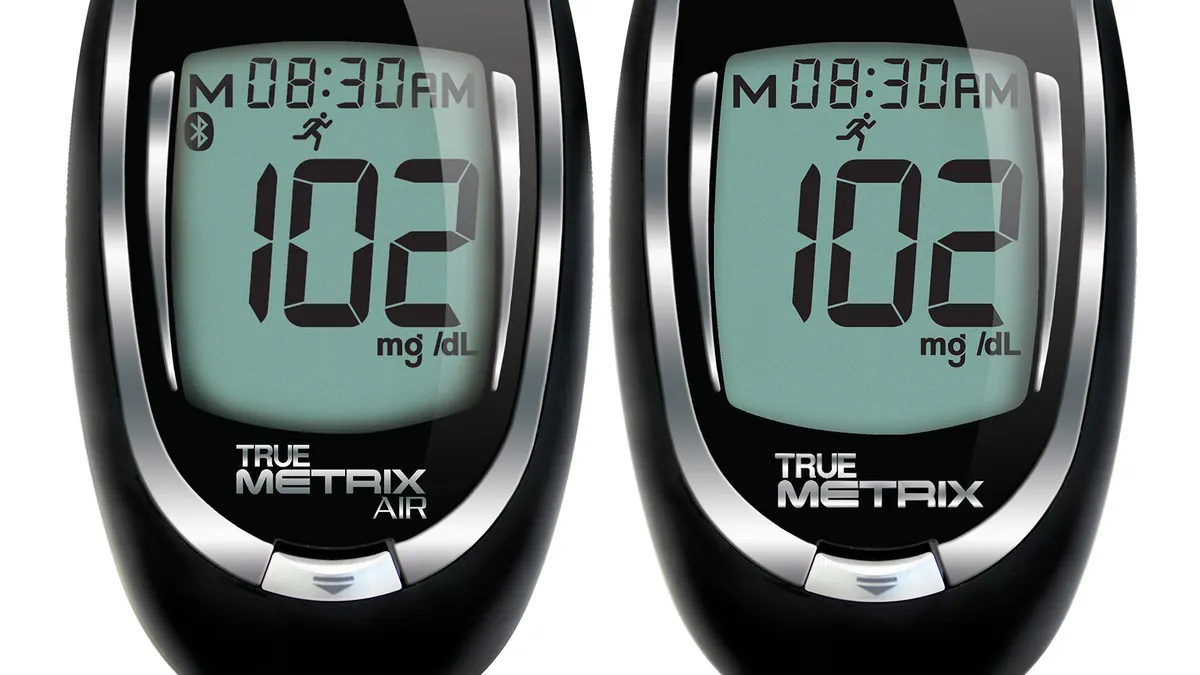 Two black, rounded devices next to each other give the same reading of 102 mg/dL.