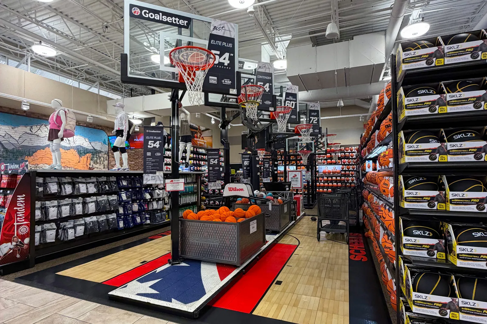 A line of basketball hoops on a mock basketball flooring at Scheels.