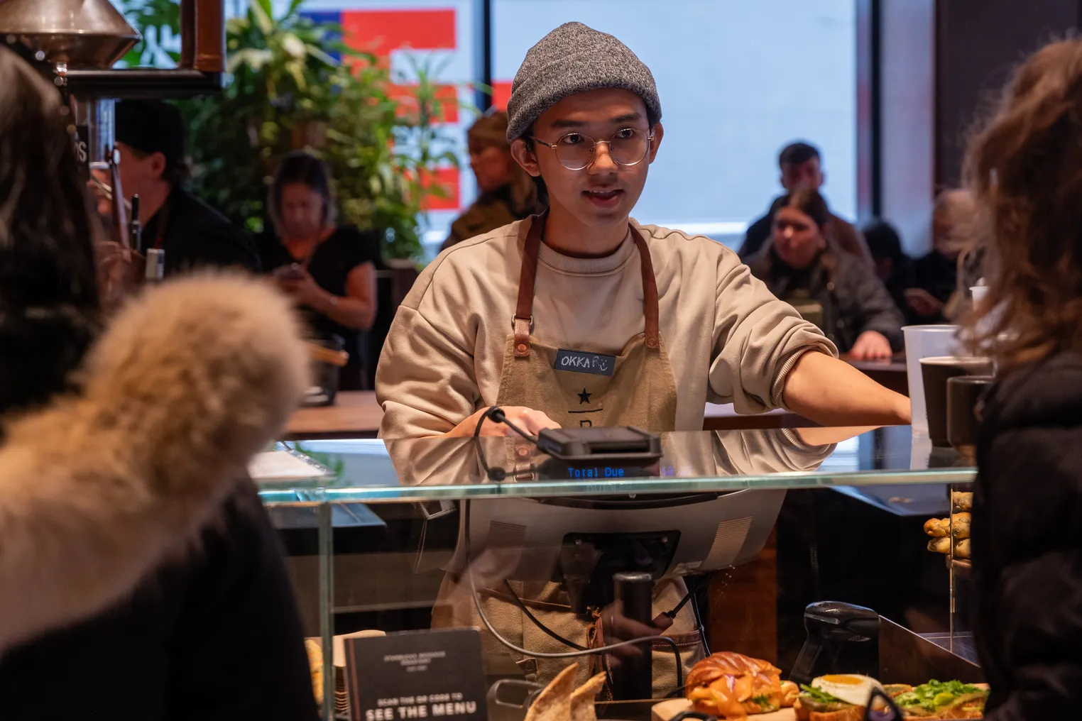 A man takes orders at a Starbucks counter.