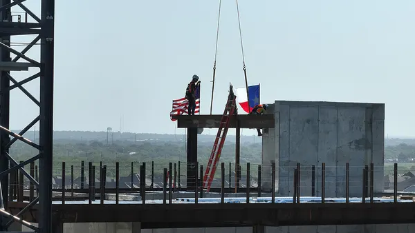 Workers help place the highest steel beam on Palo Alto Hospital in San Antonio, Texas.