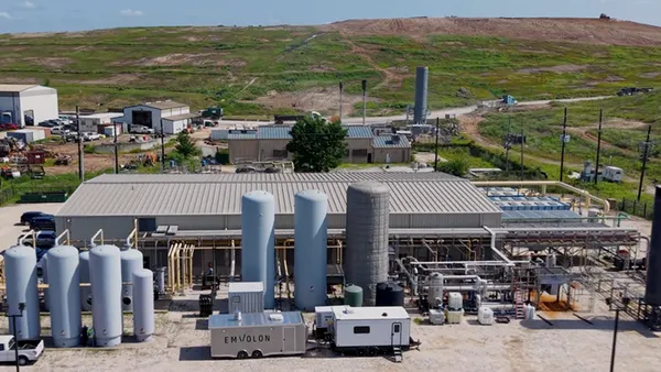 Aerial view of a small industrial facility in front of a landfill.