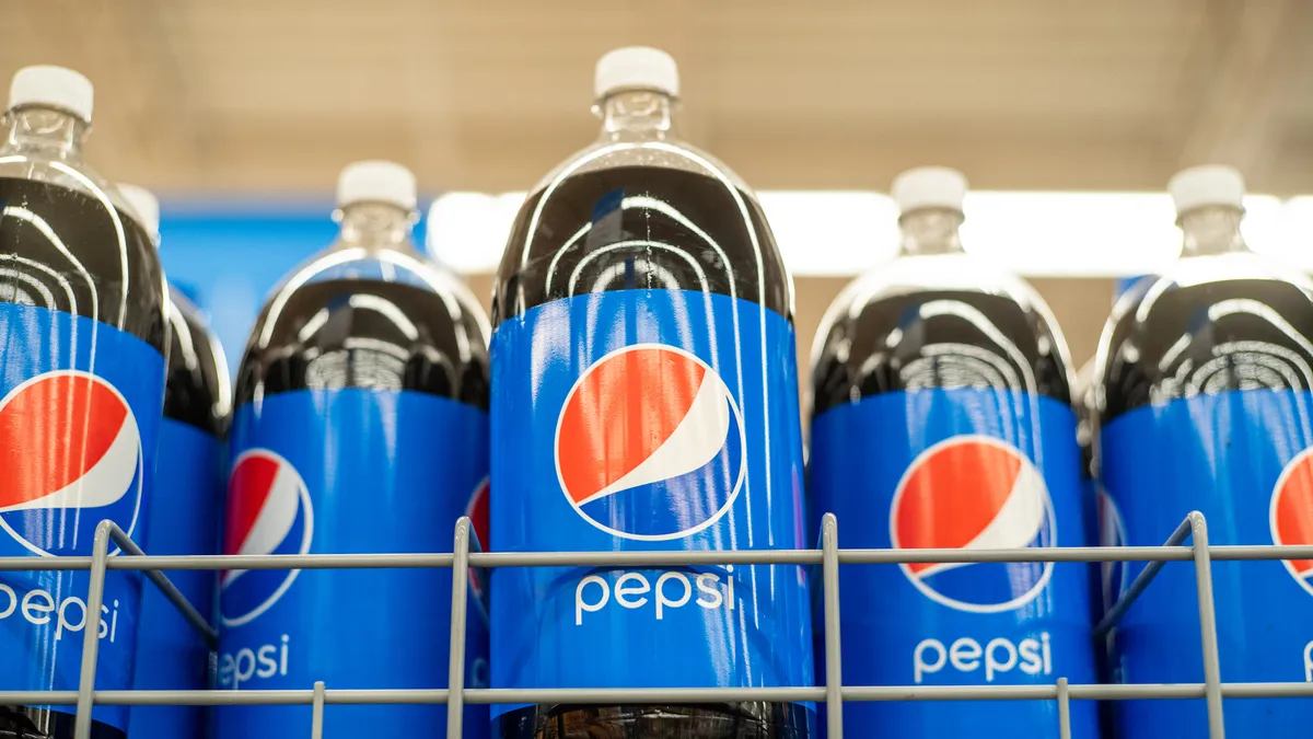 Pepsi sodas are displayed on a store shelf.