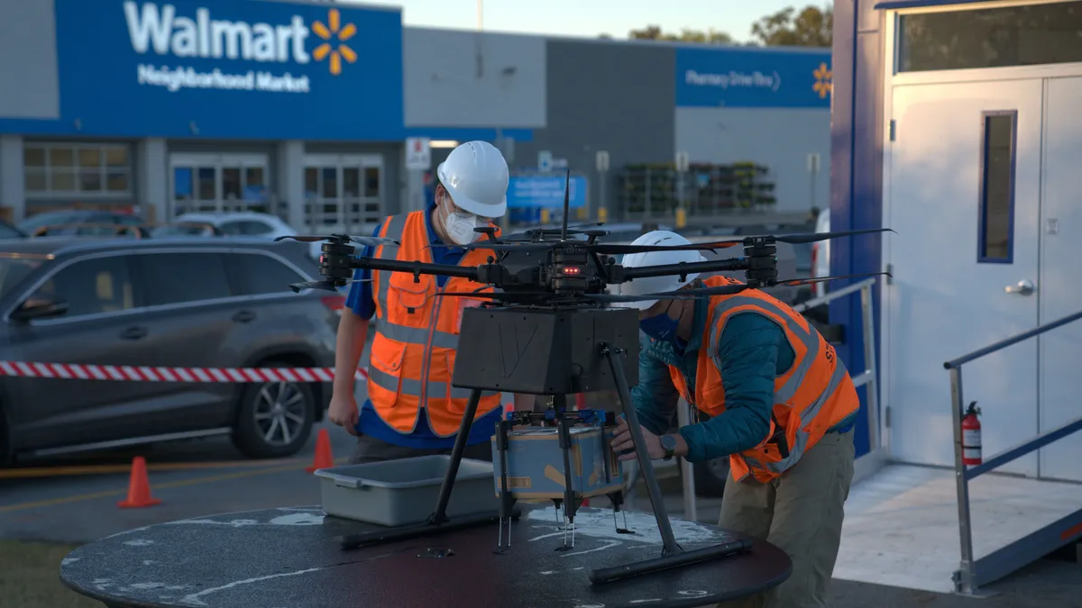 DroneUp flight engineers prepare a delivery drone to deliver a Walmart package.