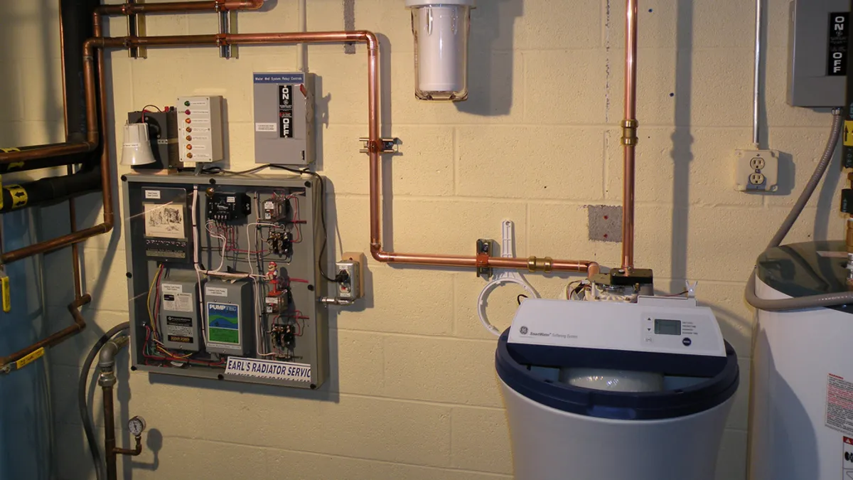 A tank-style water heater sits in a basement.