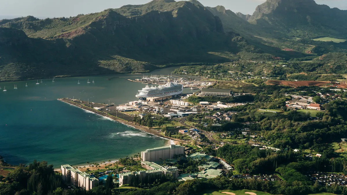 Aerial shot of buildings along coast with mountains in background