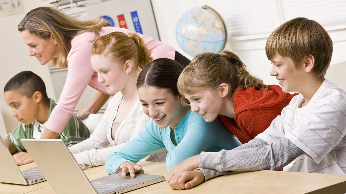 Students working on laptops in a classroom