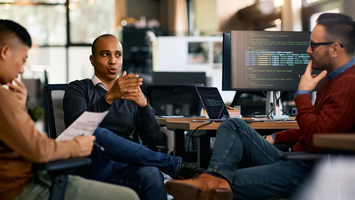 IT engineer and colleagues communicating on a meeting in the office.