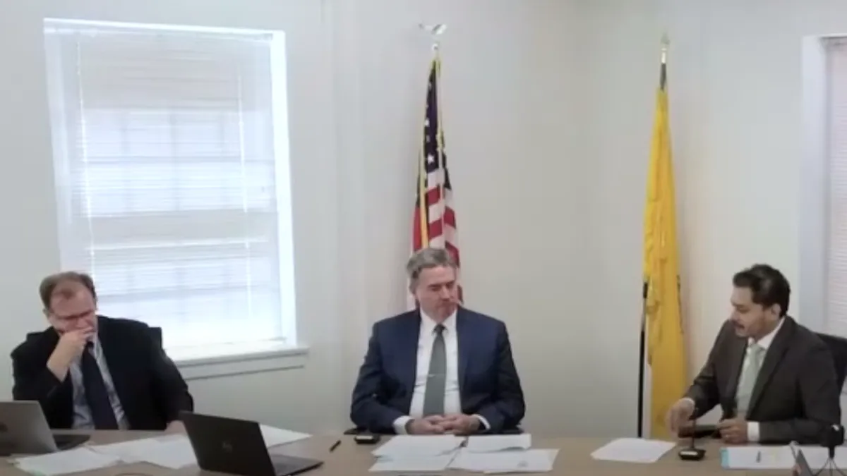 A screenshot from the June 21 open meeting of the New Mexico Public Regulation Commission. Three commissioners sit at a table discussing the open meeting schedule.