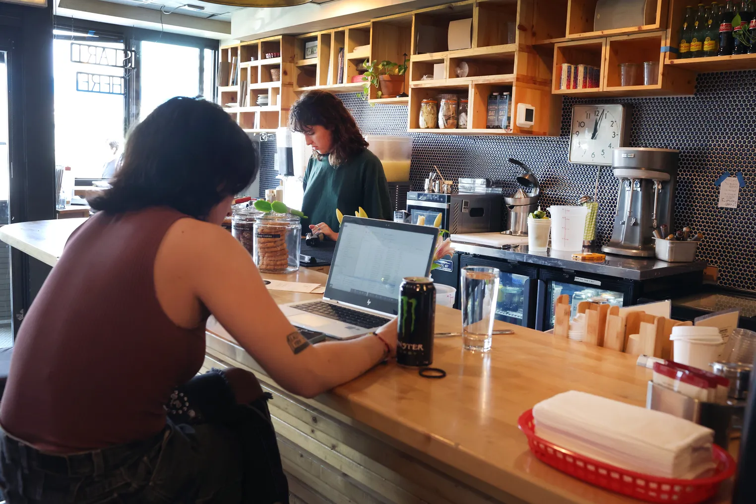 An individual workers on a laptop in a cafe.