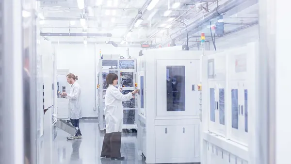 Lab assistants work in the cell assembly room at the Batteries and Energy to Advance Commercialization and National Security prototyping facility at The University of Texas at Dallas.