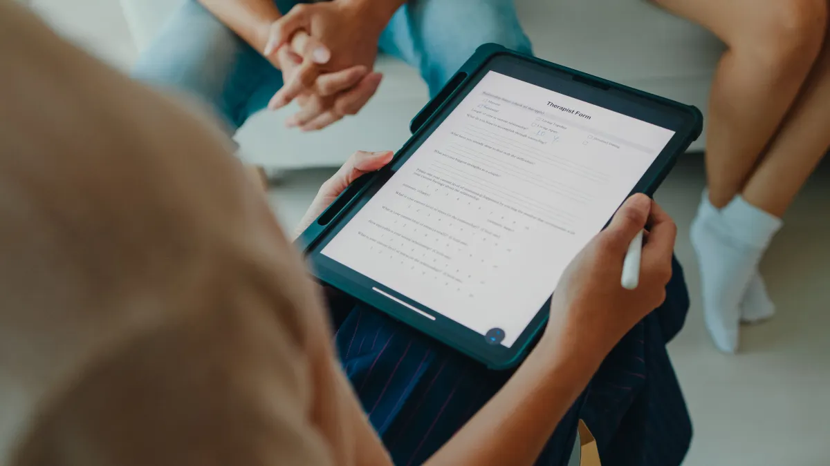 Doing a mental health survey on a tablet with a female psychotherapist