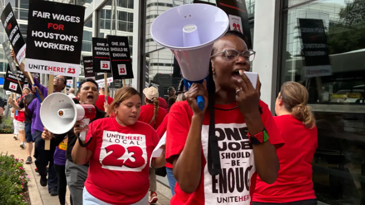 A worker speaks into a megaphone.