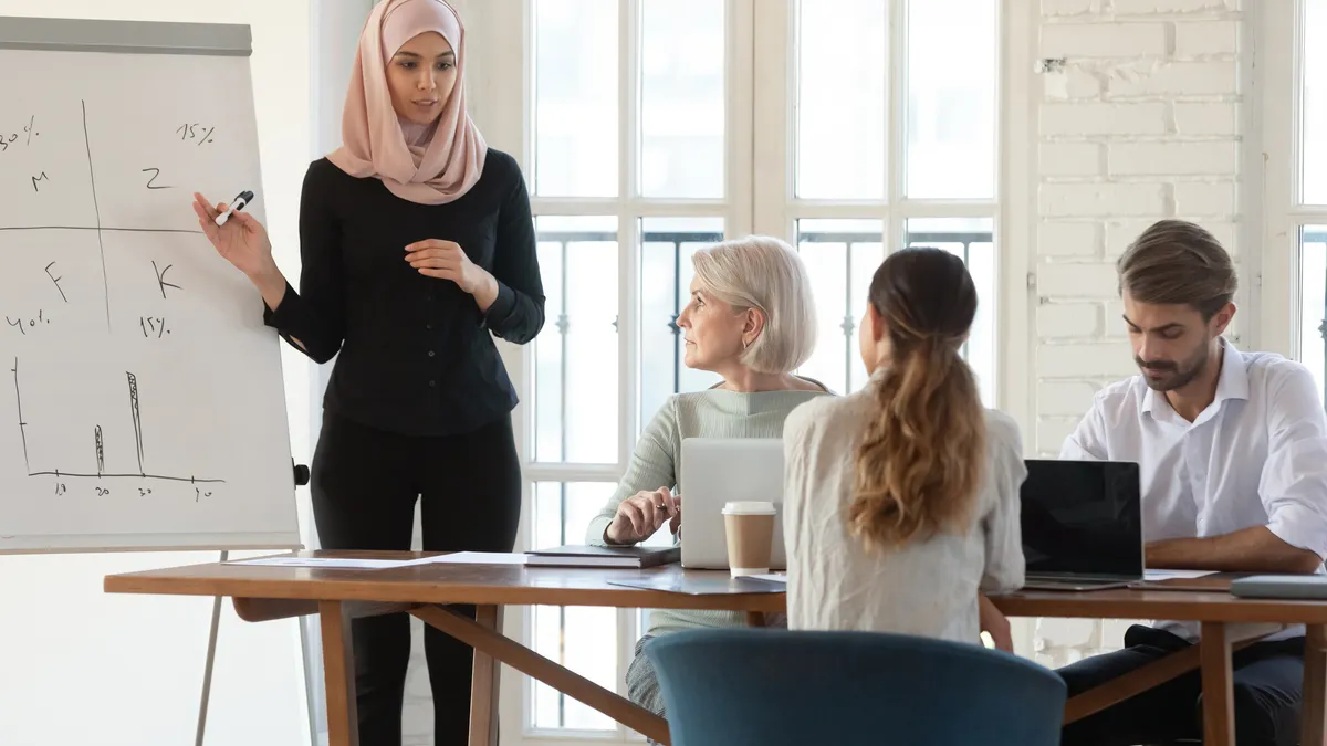 Female speaker explaining presentation to colleagues