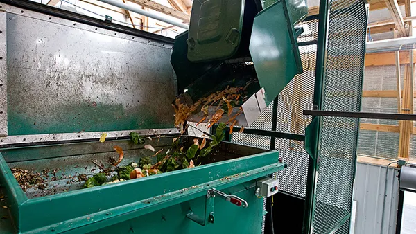 A food waste bin is poured into Ohio University's in-vessel composting vessel.