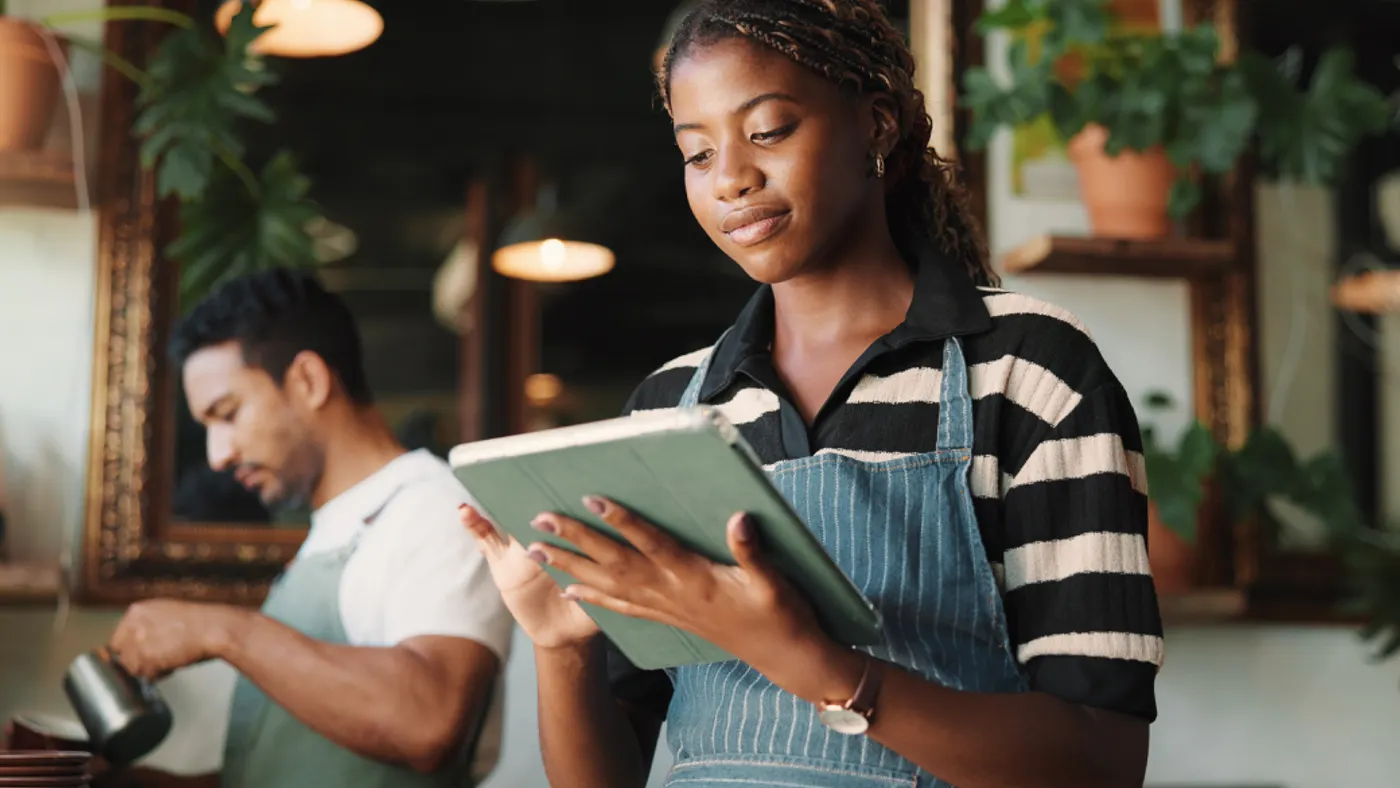 A woman in a restaurant working on a tablet