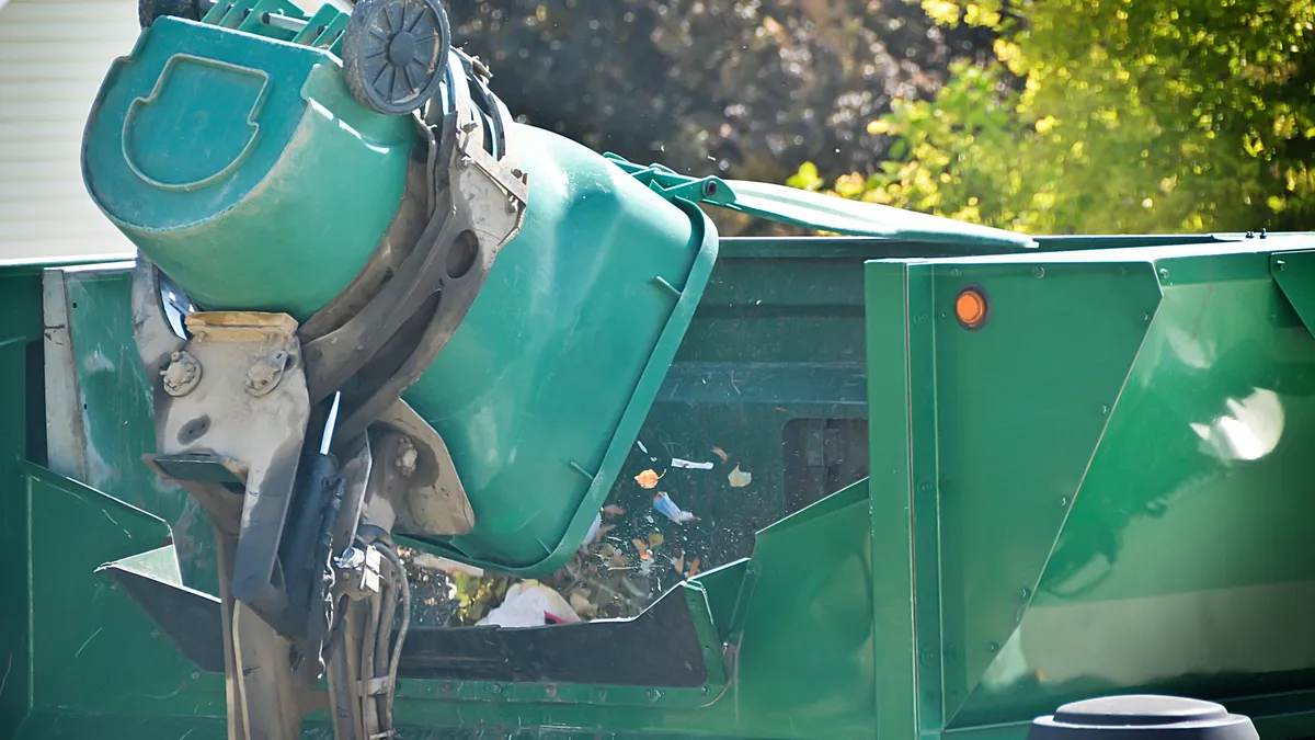 Garbage truck collecting waste