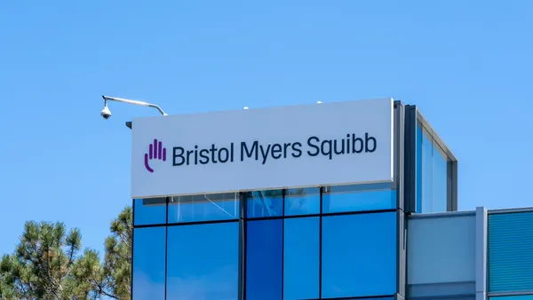A sign spelling Bristol Myers Squibb hangs on the side of an office building.