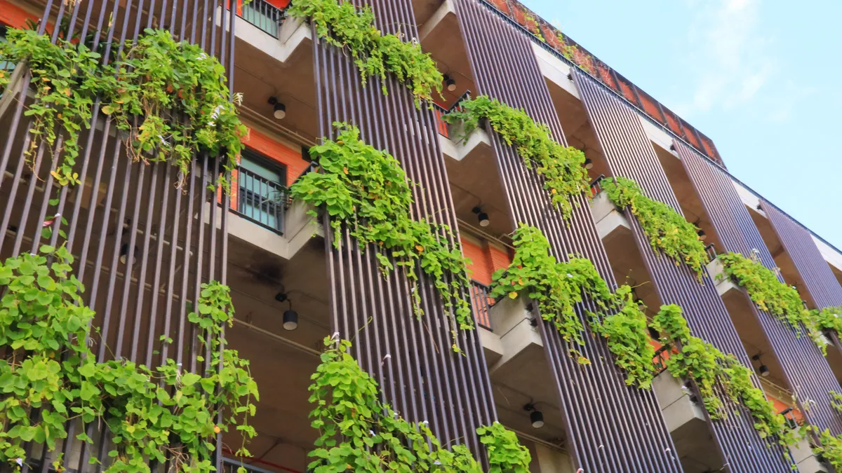 The exterior of a building features plants at each window.