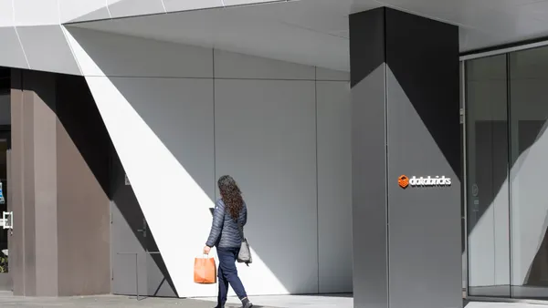 a woman walks outside of an office branded with Databricks signage
