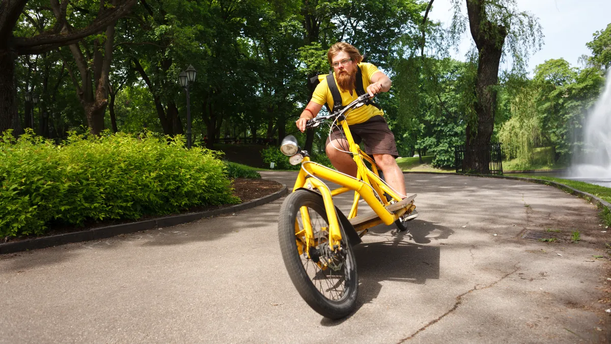 Bicycle messenger with cargo bike speeding for delivery.