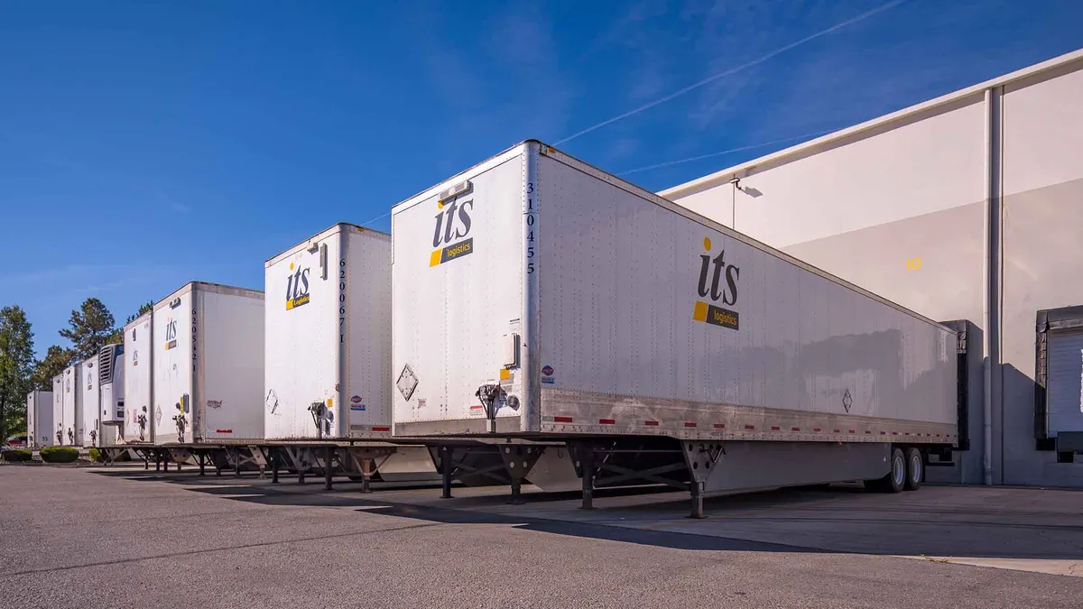 A line of drop trailers outside a warehouse.