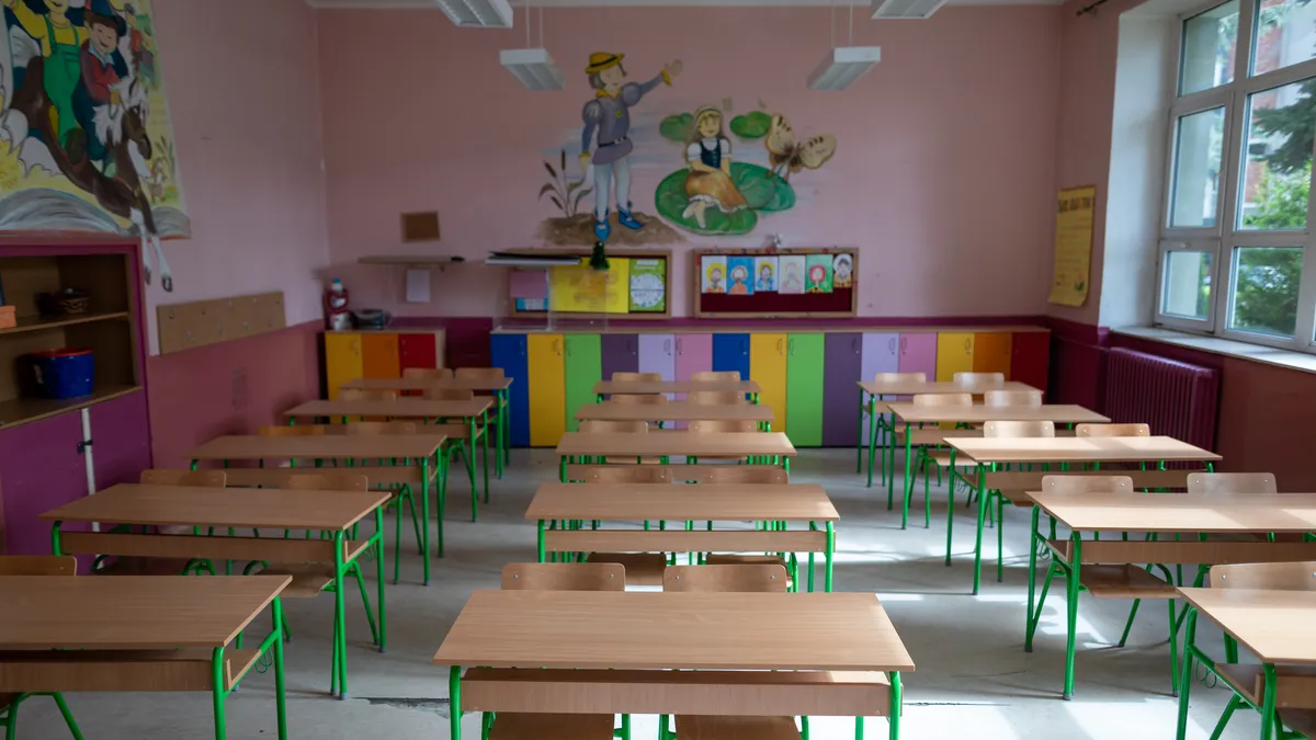 Rows of chairs sit empty in an elementary school classroom.