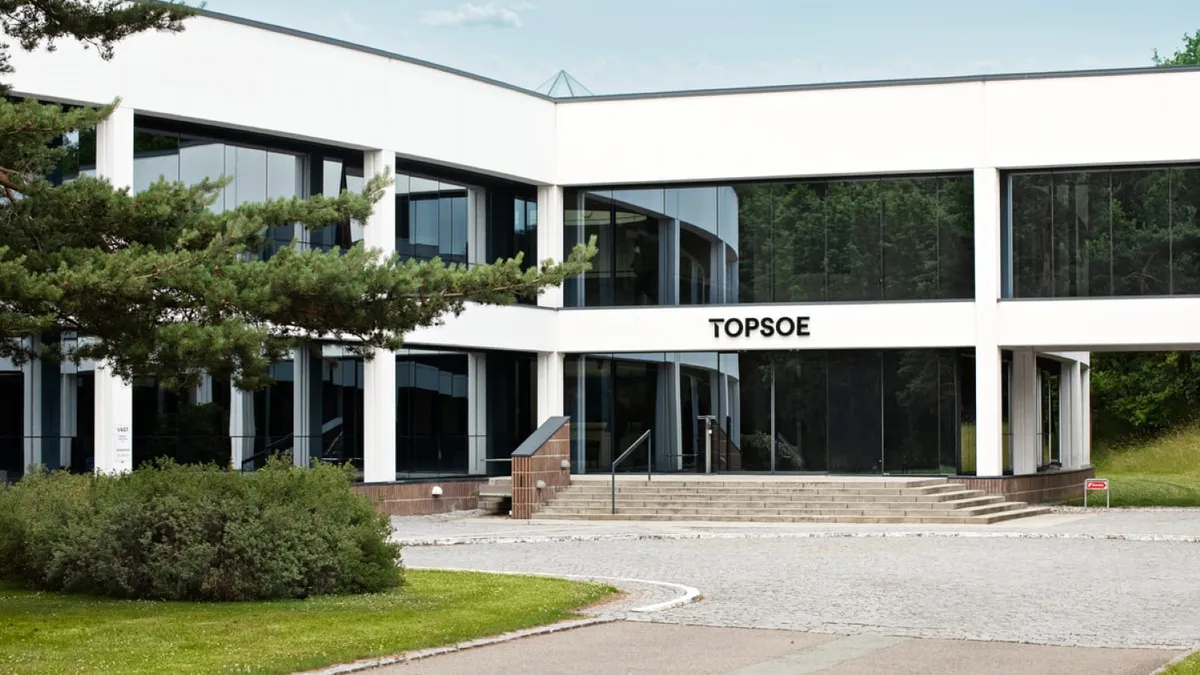 A white building with windows, with the black Topsoe logo above the glass doors.