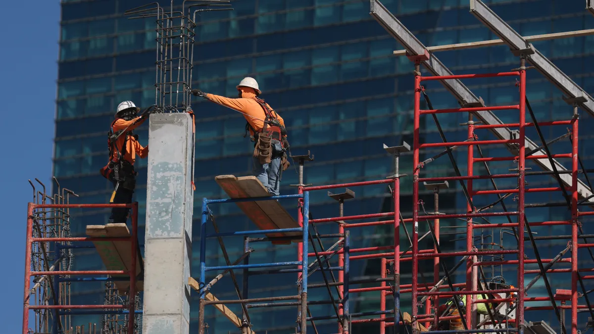 Construction workers help build a condo tower using steel rebar