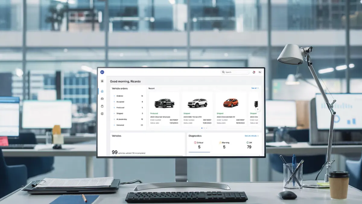 A computer display on an office desk showing a simulated OnStar Fleet Intelligence user interface.
