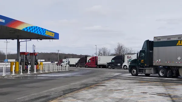 Tractor-trailers parked next to a Sunoco fueling station on I-90 eastbound.