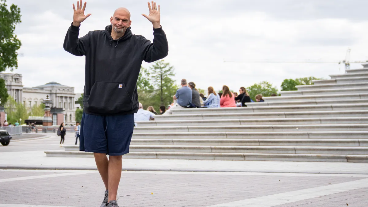 U.S. Sen. John Fetterman (D-PA) waves to reporters as he arrives at the U.S. Capitol.