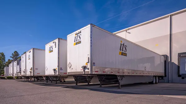 A line of drop trailers outside a warehouse.